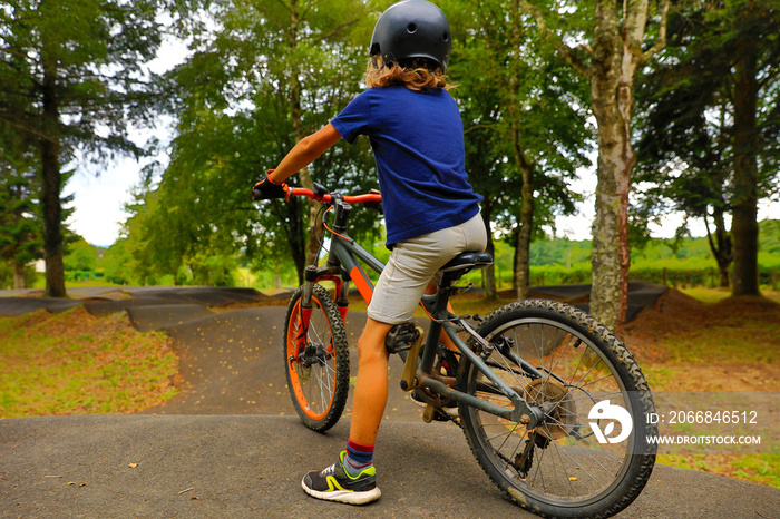 young boy riding on a bike-pumptrack, skatepark-BMX rider on a bike ready to start