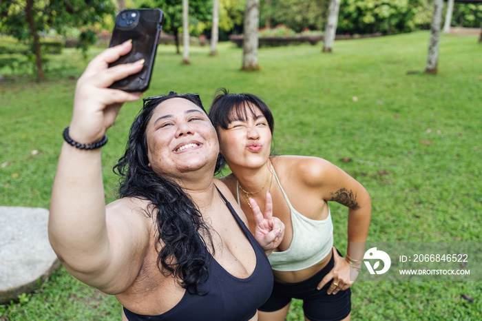 Friends taking photos of each other in the park after a workout