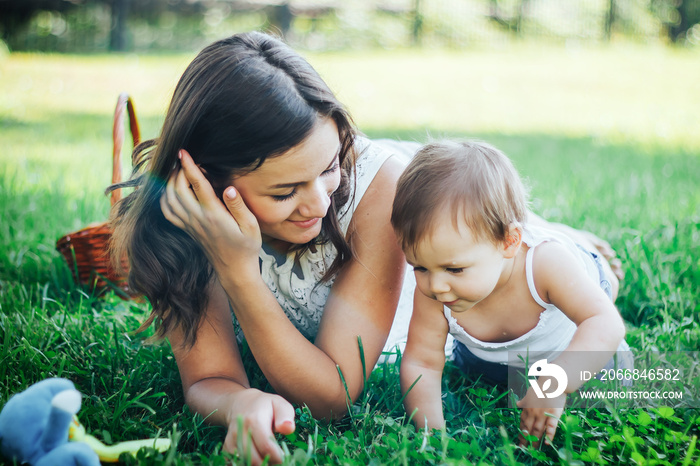 mother lie on grass with legged child