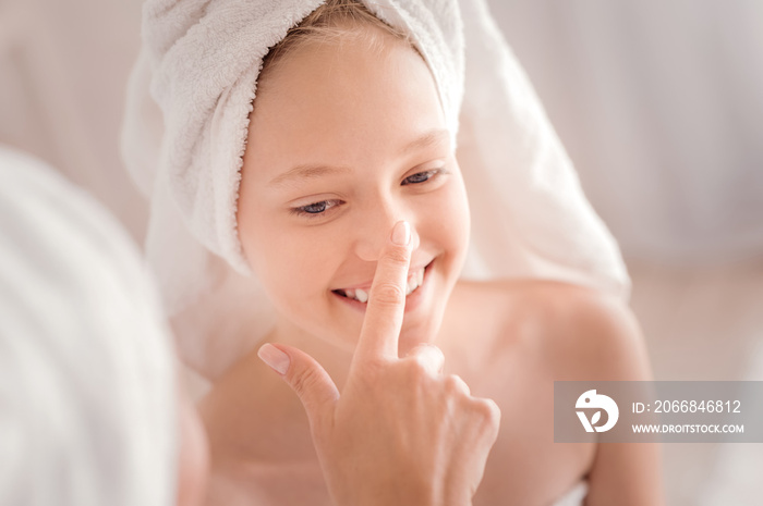 Positive emotions. Cheerful delighted happy girl looking at the finger touching her nose and smiling while experiencing positive emotions