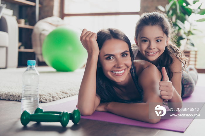 It was cool! Let’s do it one more time! Close up photo of excited satisfied cheerful impressed daughter and mother lying on the floor, demonstrating thumb-up symbol, looking in camera