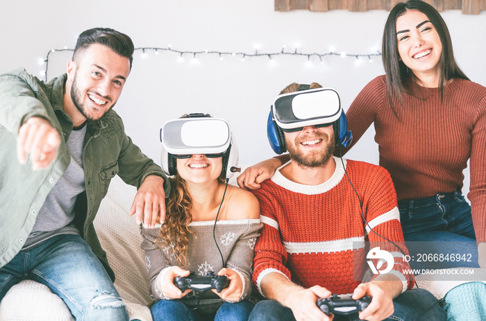 Happy millennials friends playing video games with virtual reality headset - Young people having fun with new vr online trend technology - Gaming, tech and youth concept