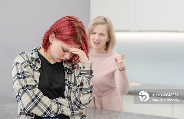 Family conflict. Angry mother screams at guilty teen daughter