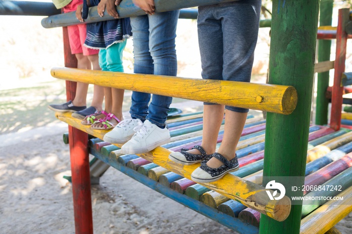 Low section of children standing on jungle gym