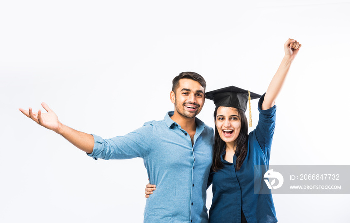 Indian Graduate female student wearing hat celebrating success with male friends