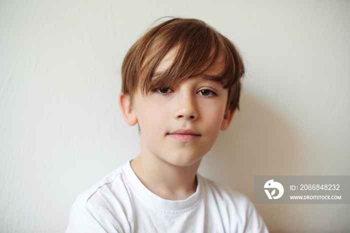 Schoolboy with good mood in the morning. Handsome boy with blonde hair looking at camera.