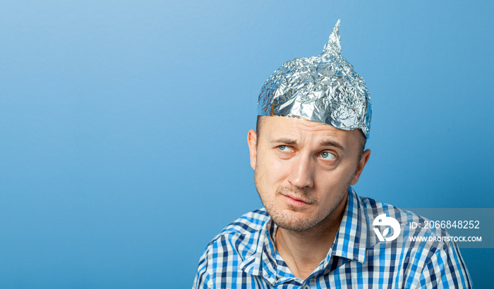 Foil hat on man. Man with a surprised face. Protects from reading think