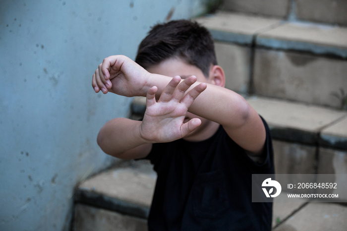 A little boy protects himself with his palms and covers his face. Stop abusing boy violence. violence, terrified , A fearful child