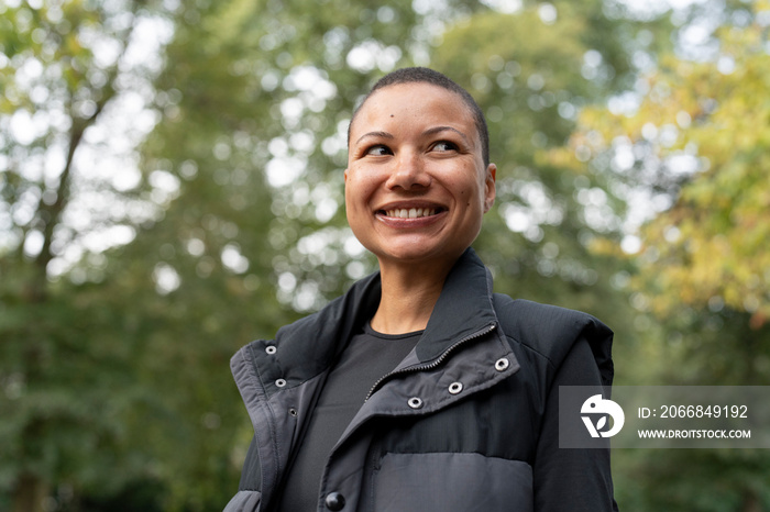 Portrait of smiling woman in sports clothing in park