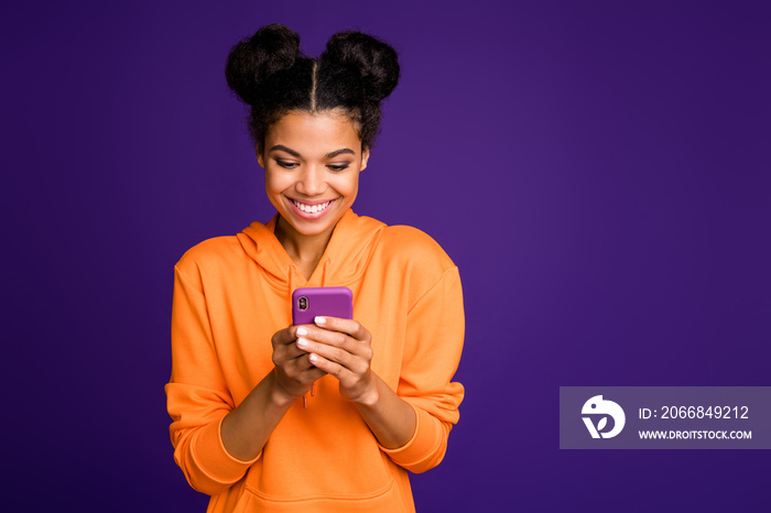 Photo of cheerful positive cute pretty nice woman smiling toothily looking into telephone for new information isolated vivid color purple background