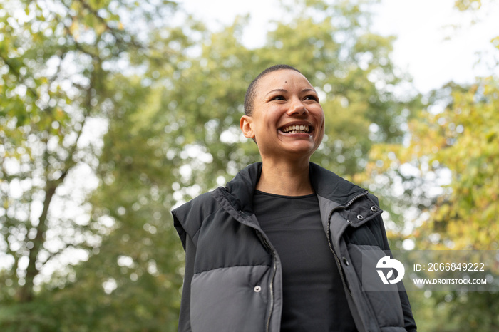 Portrait of smiling woman in sports clothing in park