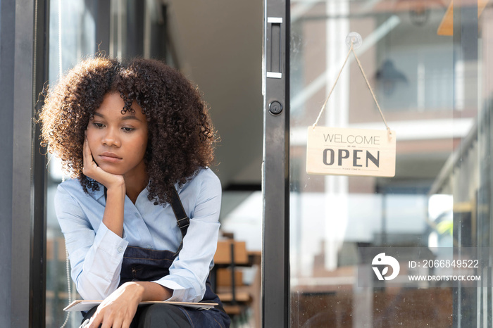 black woman waiter of street cafe is waiting for clients, customersm she is bored, no people in their cafe. small business owner.