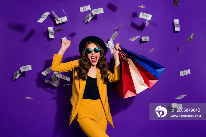 Portrait of her she nice lovely cheerful cheery glad wavy-haired lady shopaholic carrying bags flying 100 million budget salary success isolated over bright vivid shine violet lilac background