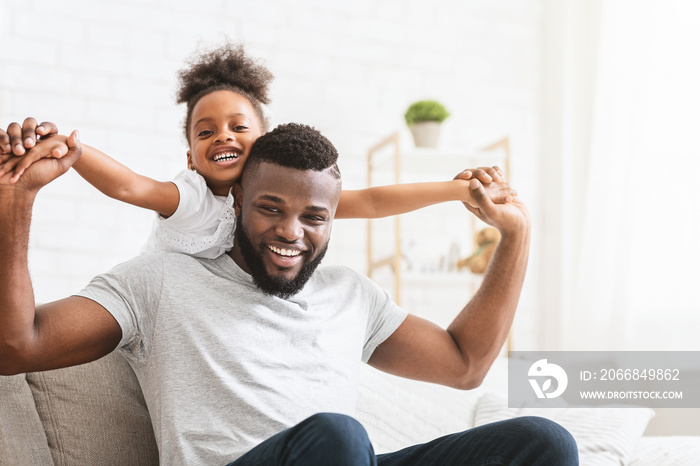 Lovely black family father and daughter posing at home