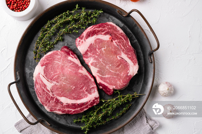 Raw rib eye steak of beef, on white stone table background, top view flat lay