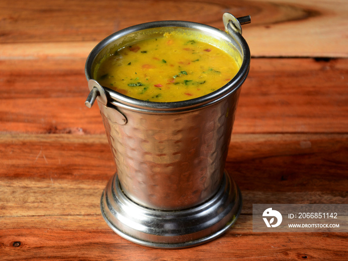 Authentic Indian popular food Dal fry or Traditional Indian soup lentils on rustic wooden background. selective focus