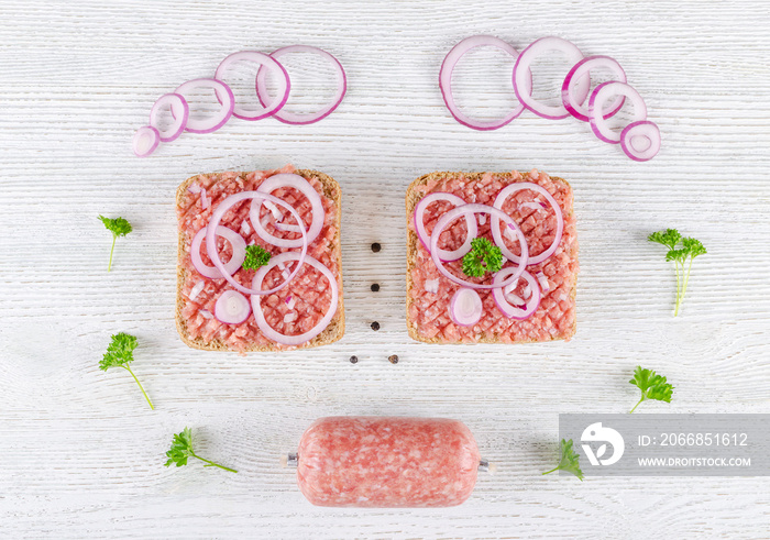 german sandwich mett ground pork, bun and raw meat with onion, pepper and parsley, like a face