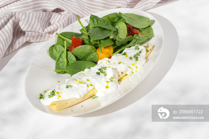 Breakfast Scrambled eggs with stracciatella and vegetable salad on white background for restaurant menu.