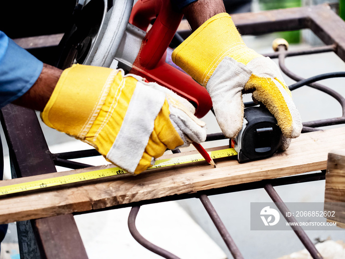 New House Building Project.Foreman engineering construction african Technicians skill carpentry uses tape measure meters wearing blue protective clothing are cutting off wood industrial factory