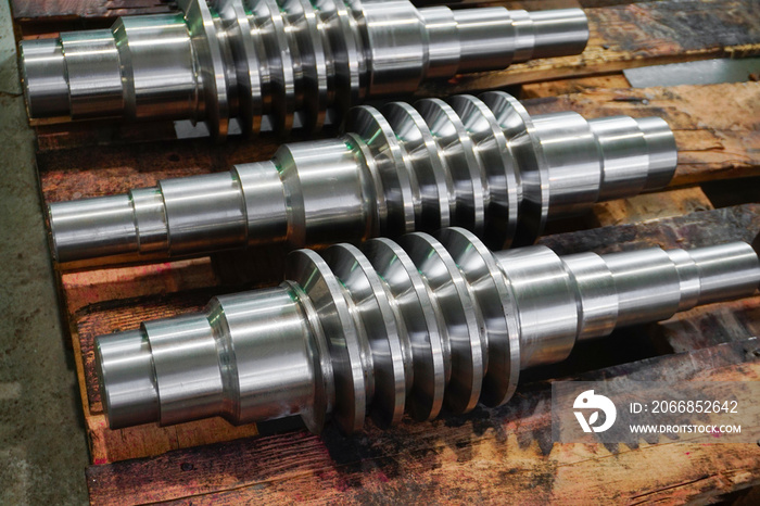 The worm shaft after processing lies on a wooden rack, the production of helically screw products.