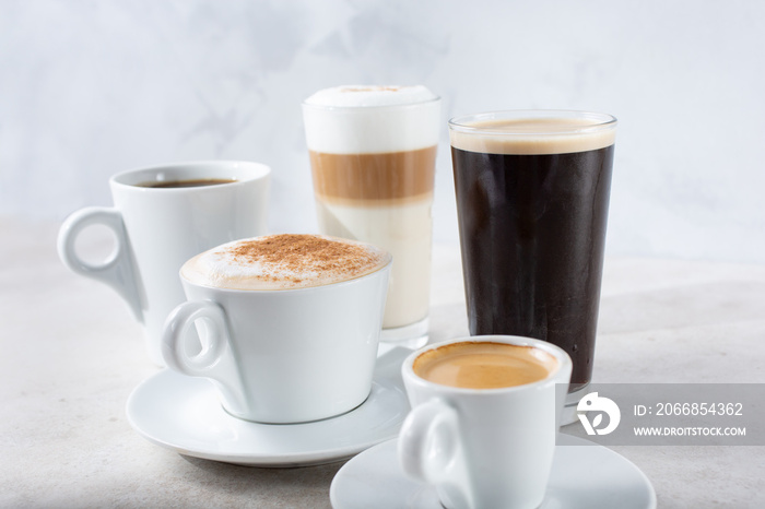 A view of a collection of popular coffee drinks in cups and glasses.