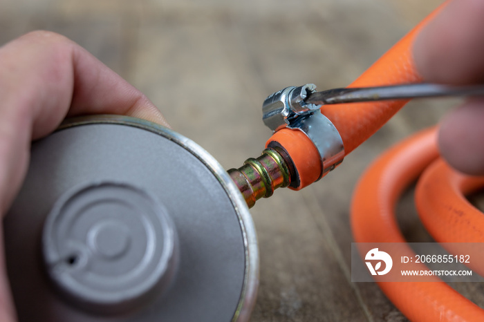 Regulator for propane-butane gas cylinder and accessories on a wooden workshop table. Gas accessories in the workshop.