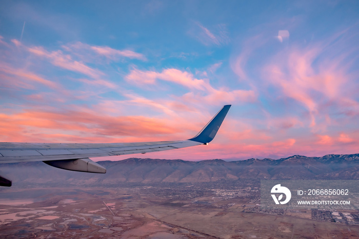 flying over rockies in airplane from salt lake city at sunset