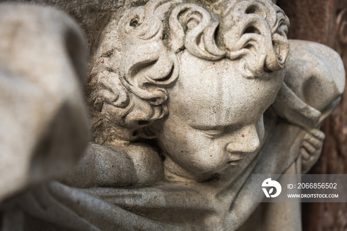 White sandstone sculpture of an angel wrapped in sheets