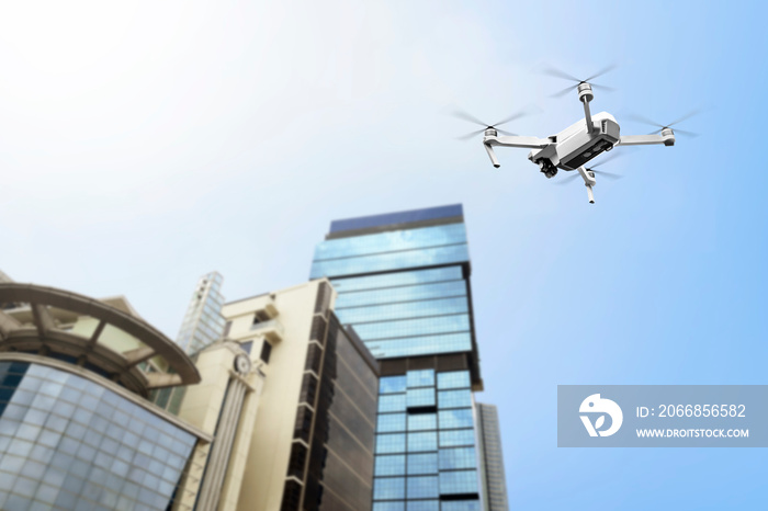 White drone with camera flying to the top of modern building