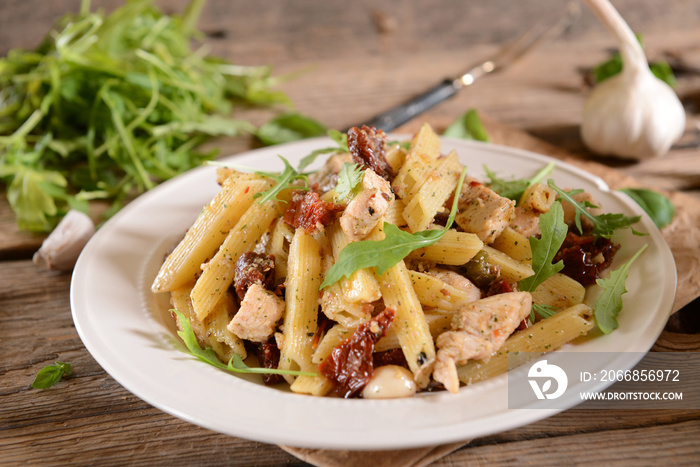 Penne pasta with chicken, dried tomatoes and ruckola