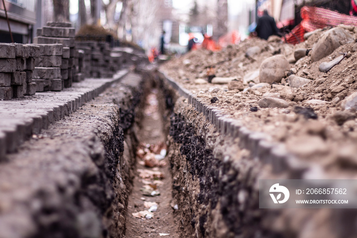 Underground road communications repair. Trench for city communication rehabilitation.