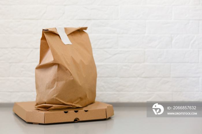 Disposable bag of kraft paper on a wooden table. Beautiful sunshine. Copy space. Kraft design.