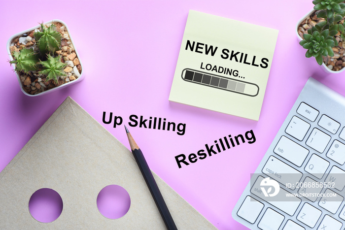 Reskilling and up skilling development concept and changing skill demand idea. New skills loading written on sticky note on workspace