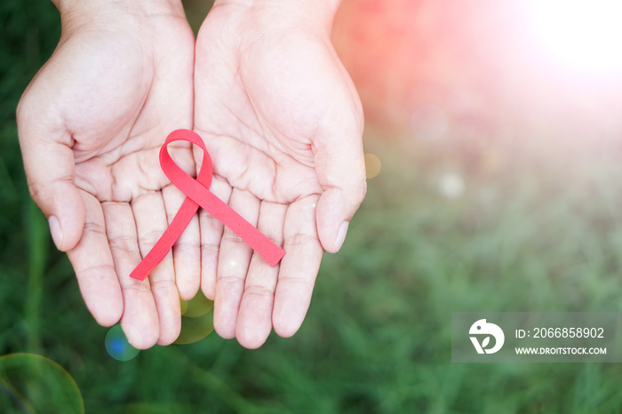 Red ribbon in hands. Concept : Aids, alcohol, tobacco, drugs  and violence prevention awareness campaign. National Red Ribbon Week. A symbol of the fight against HIV, AIDS and cancer.