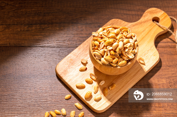 Roasted and salted peanuts in bowl on wood table. Organic Delicious Snack