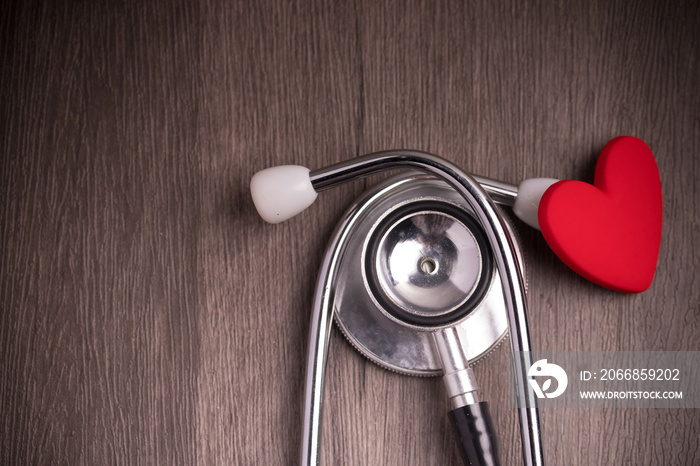 Stethoscope with red heart on gray background. Heart health care concept.