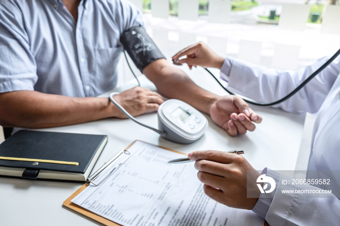 Doctor using stethoscope checking measuring arterial blood pressure on arm to a patient in the hospital