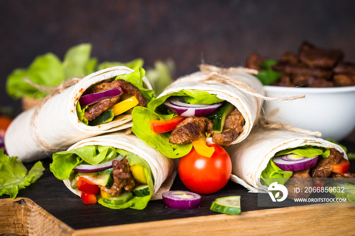 Burritos tortilla wraps with beef and vegetables.