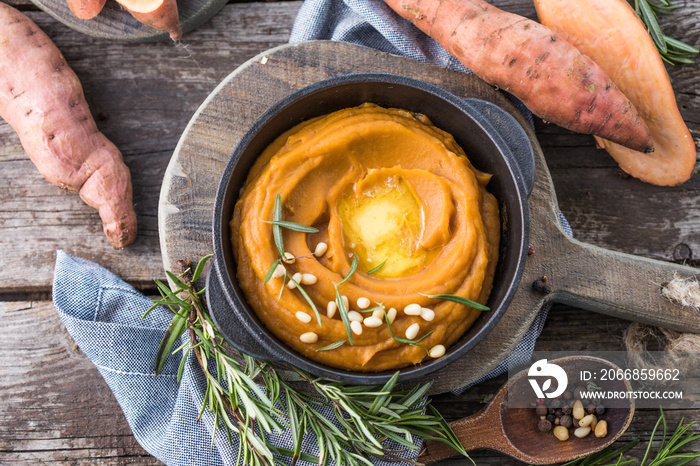 Spicy mashed sweet potato or sweet potato puree with rosemary in a saucepan on a table.  top view from above.