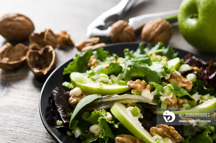 Fresh Waldorf salad with lettuce, green apples, walnuts and celery on wooden table. Close up