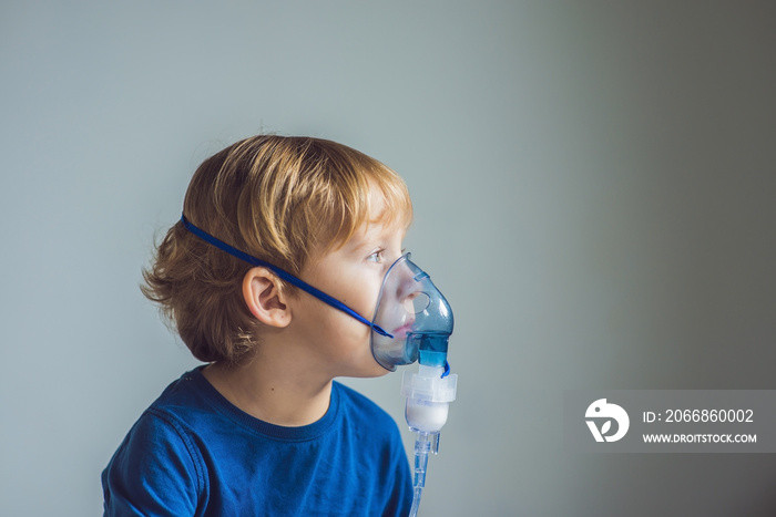 Boy making inhalation with a nebulizer at home