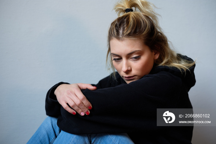 Sad face expression of young girl seated