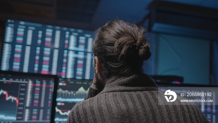 Professional stock broker long-haired hipster man doing crypto stock chart analysis on monitors