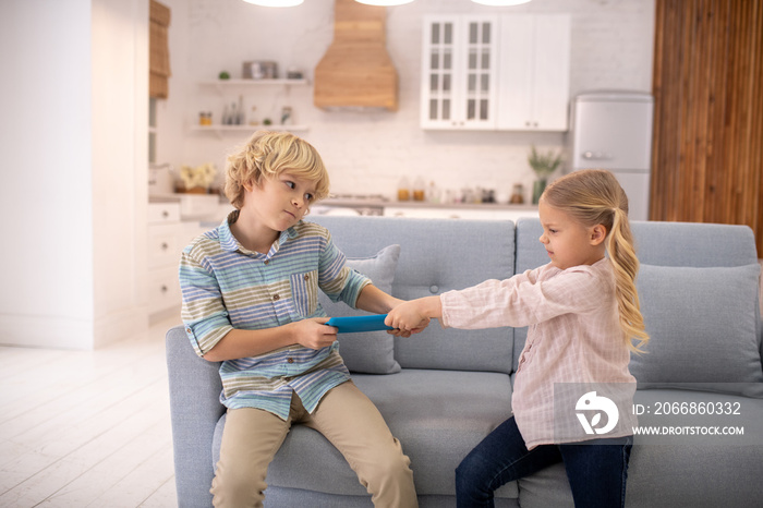 Children arguing, taking tablet from each other