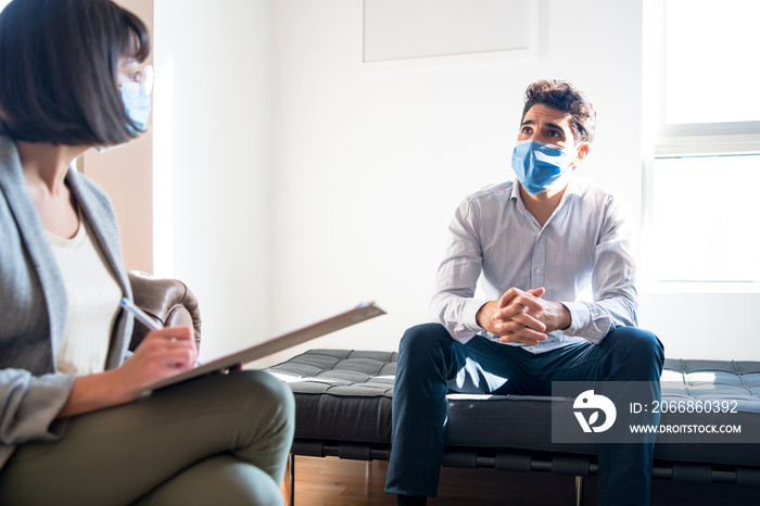 Psychologist talking with patient on therapy session.