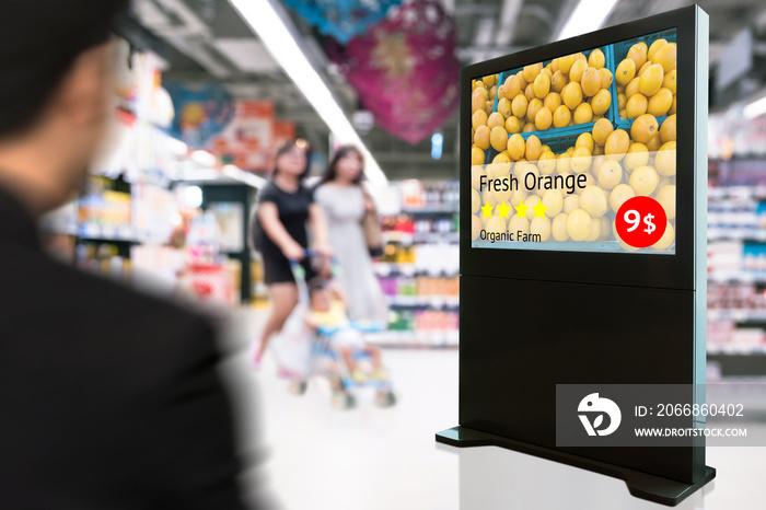 Intelligent Digital Signage , Augmented reality marketing and face recognition concept. Interactive artificial intelligence digital advertisement fresh orange organic farm in retail shopping Mall.