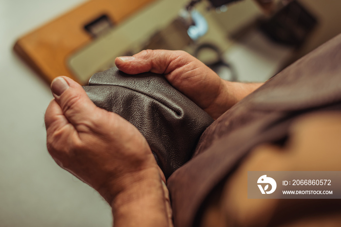 Cropped view of shoemaker checking seam on genuine leather