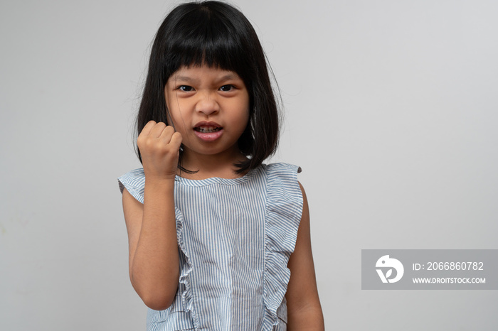 Portrait of Asian angry and sad little girl on white isolated background, The emotion of a child when tantrum and mad, expression grumpy emotion. Kid emotional control concept