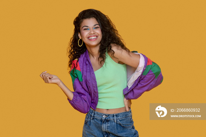 Cute dark-haired young girl in bright jacket looking joyous