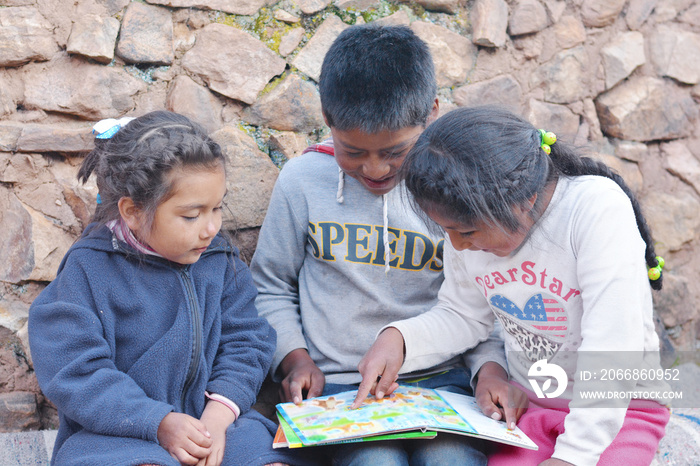 Native american kids reading a  book.